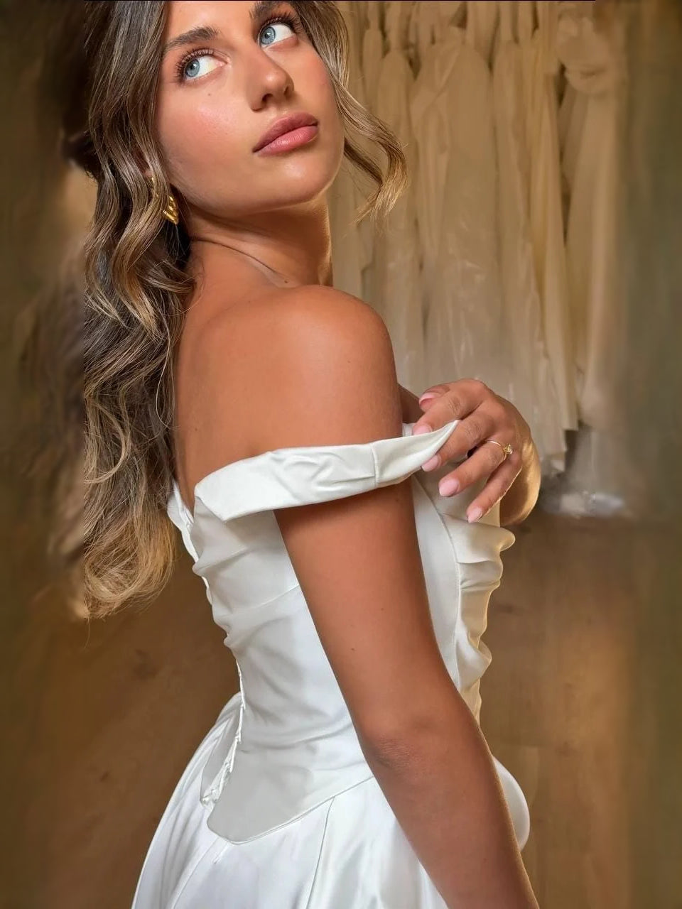 Ivory satin off-shoulder sleeve detail on a draped corset A-line wedding dress