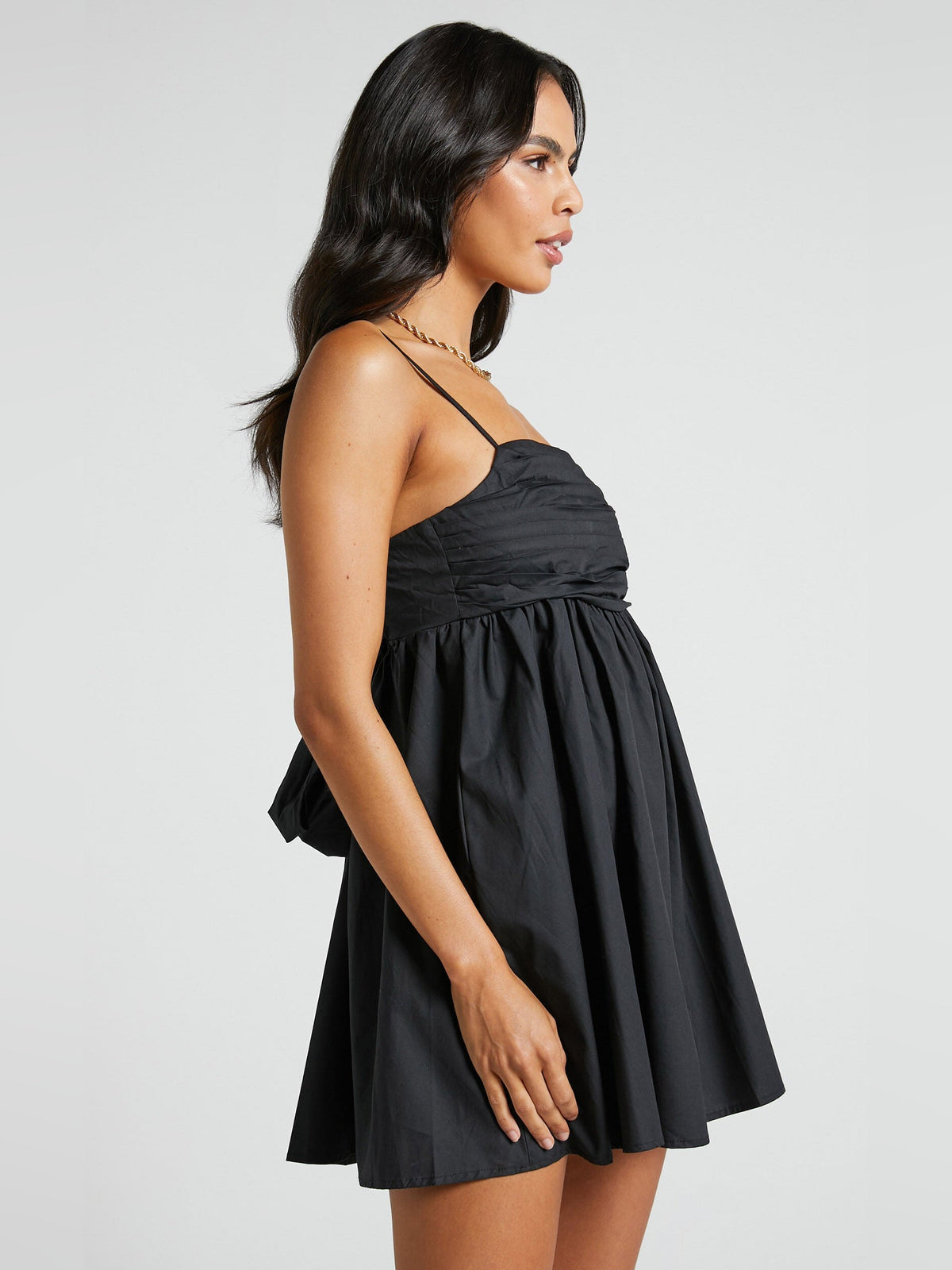 Black mini dress with spaghetti straps, ruched bodice, and flared skirt