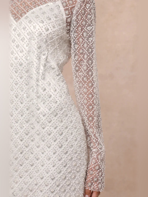 White sequin mesh sleeve close-up with repeating diamond pattern.
