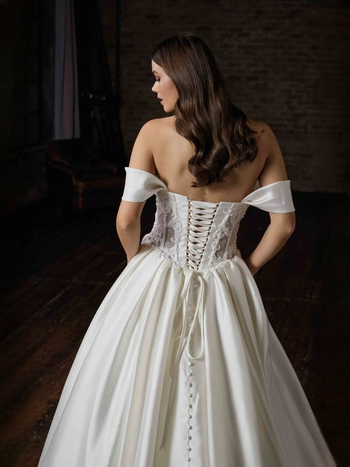 Ivory satin wedding dress with corset back lacing and off-shoulder sleeve details