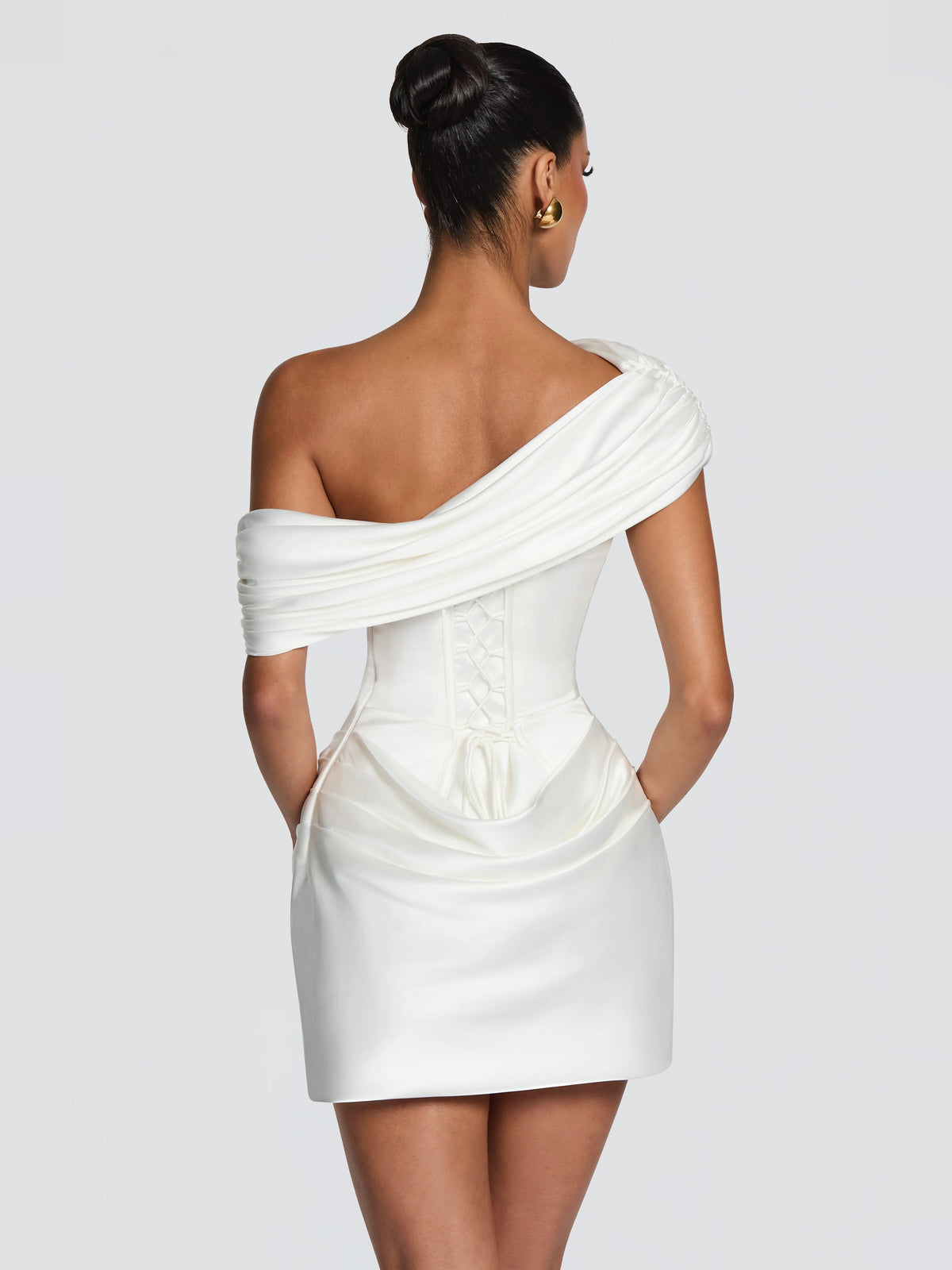 Back view of ivory corset mini dress with draped one-shoulder strap