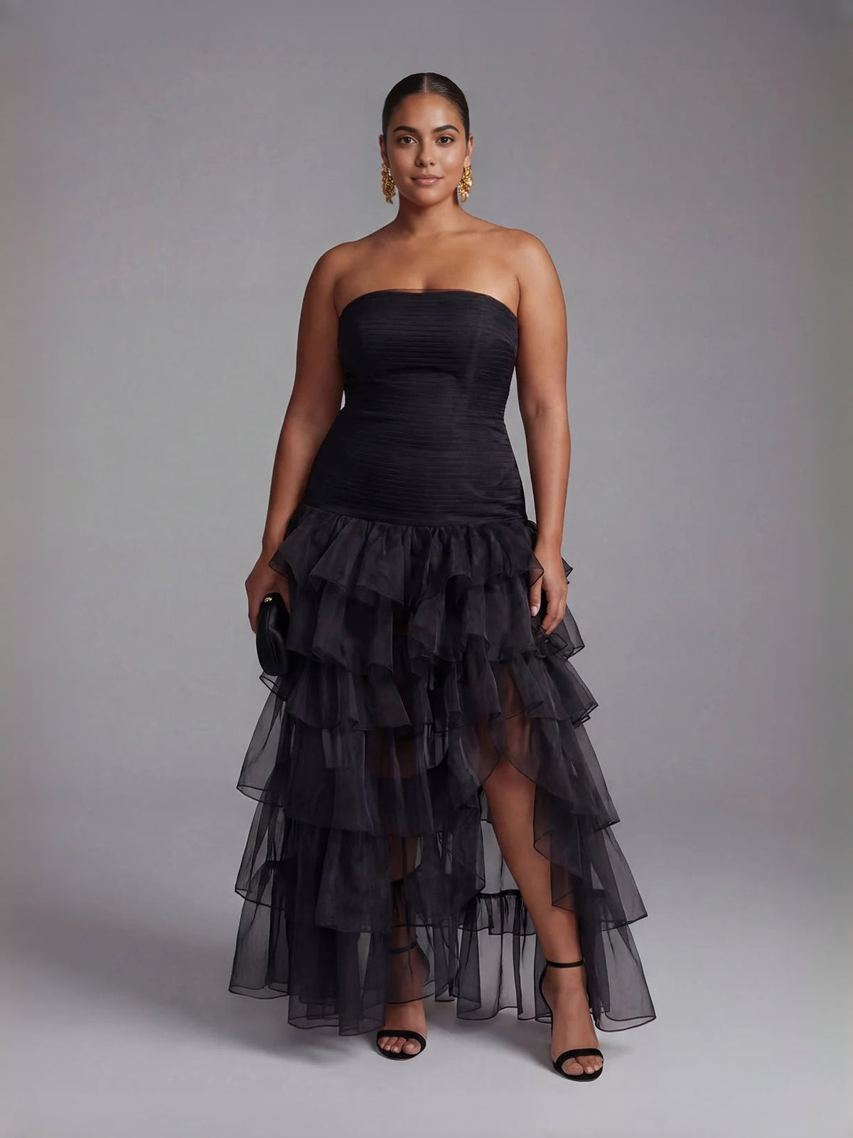 Black strapless prom dress with ruched top and tiered ruffle skirt with slit