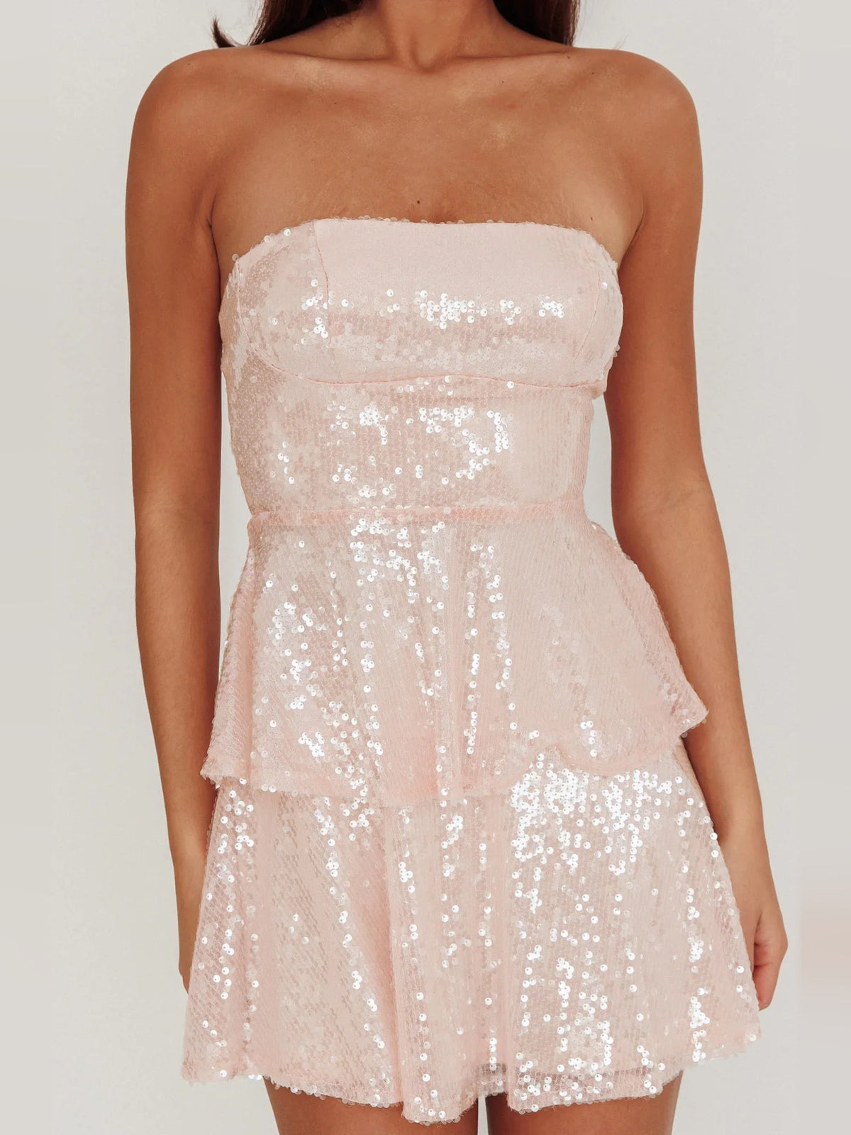 Blush pink strapless sequin mini dress with layered ruffle tiers and sweetheart neckline