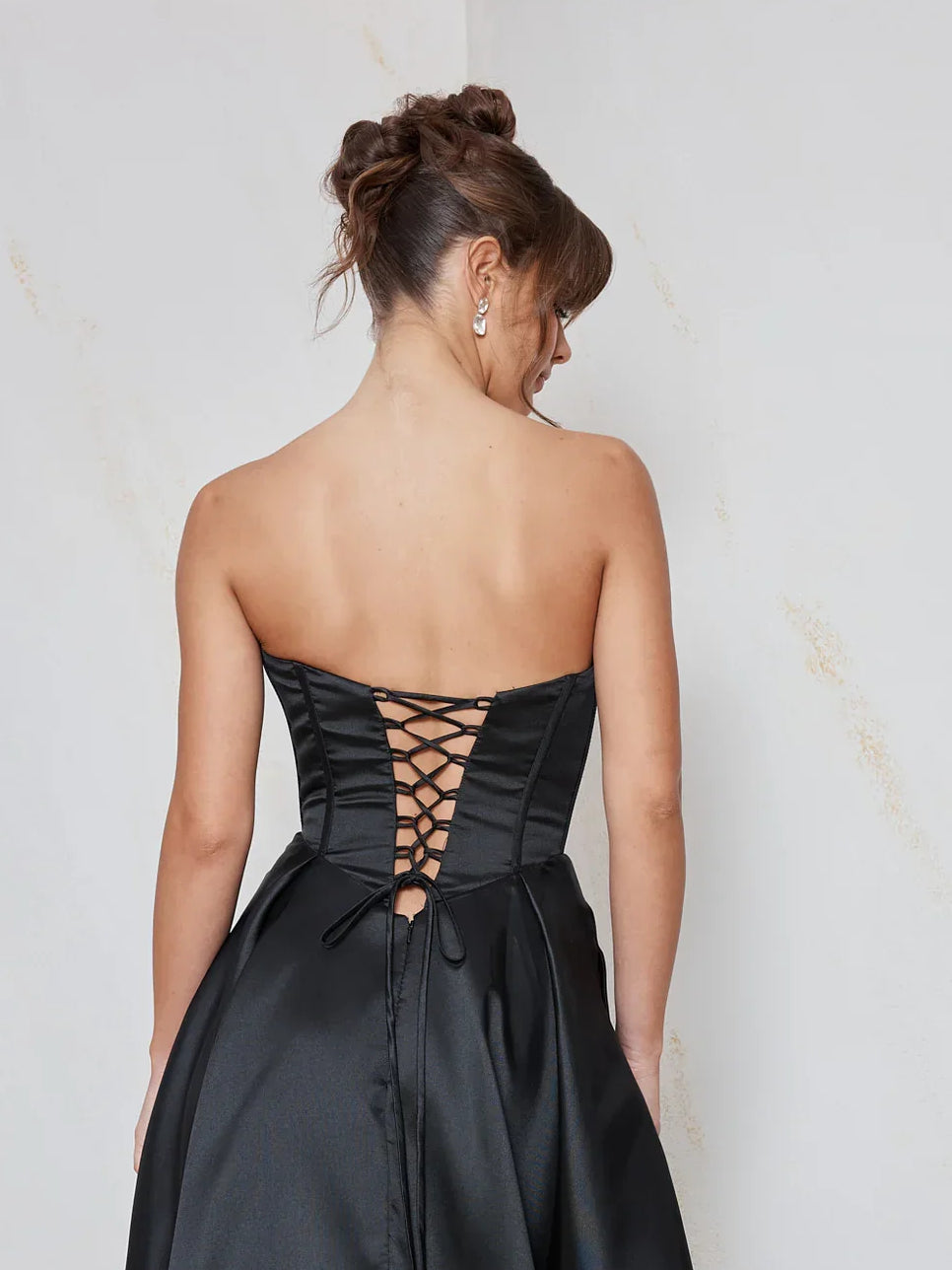 Black corset-style dress with lace-up open back and crisscross detail, floor length