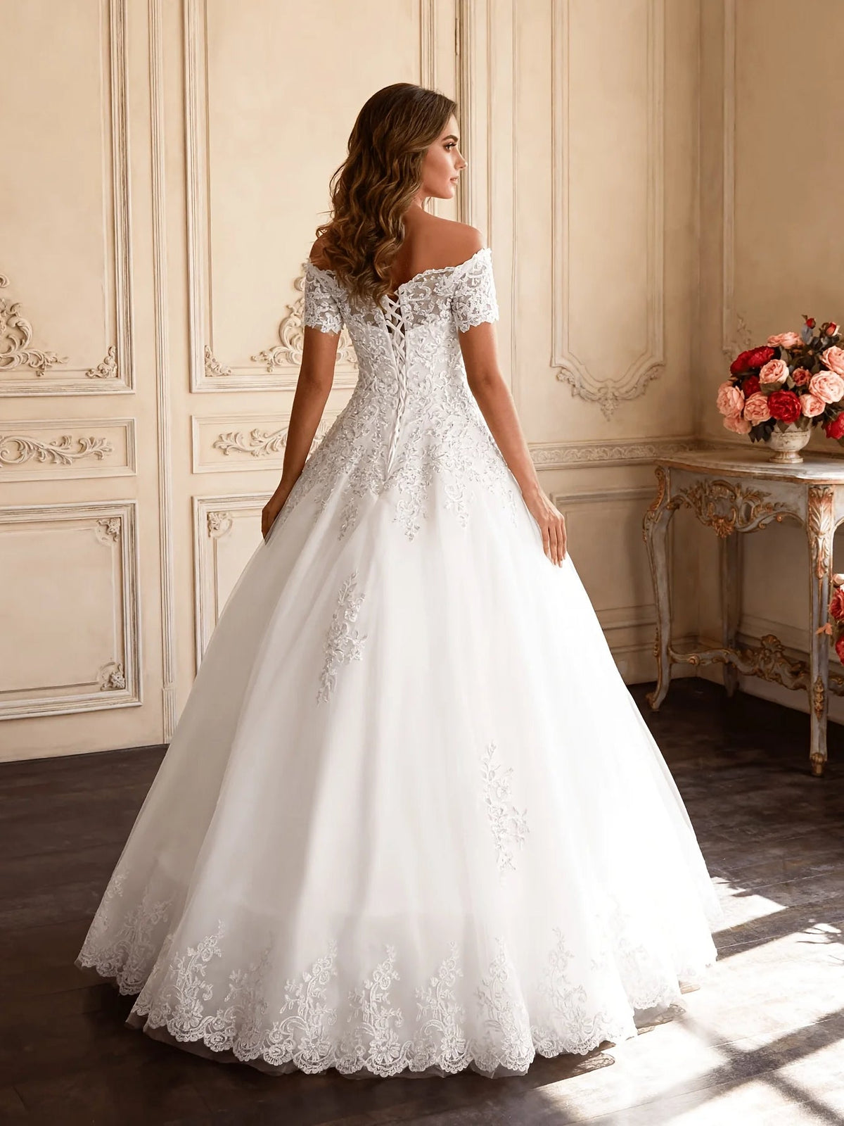 Ivory off-shoulder lace ball gown wedding dress shown from side view, full tulle skirt