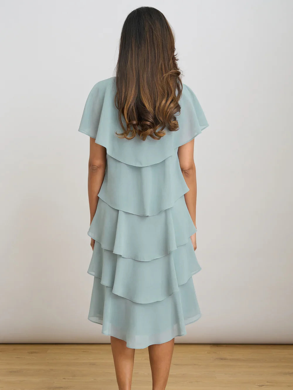 Sage green V-neck tiered chiffon knee-length dress from back view with layered ruffles