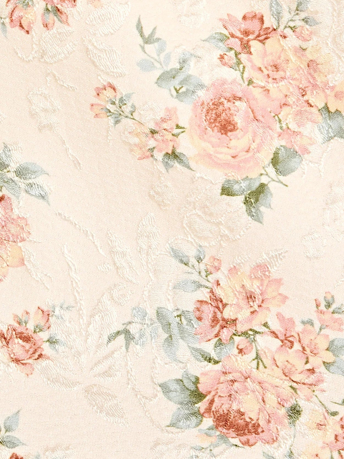 Light pink floral fabric close-up with embossed texture and rose bouquet pattern