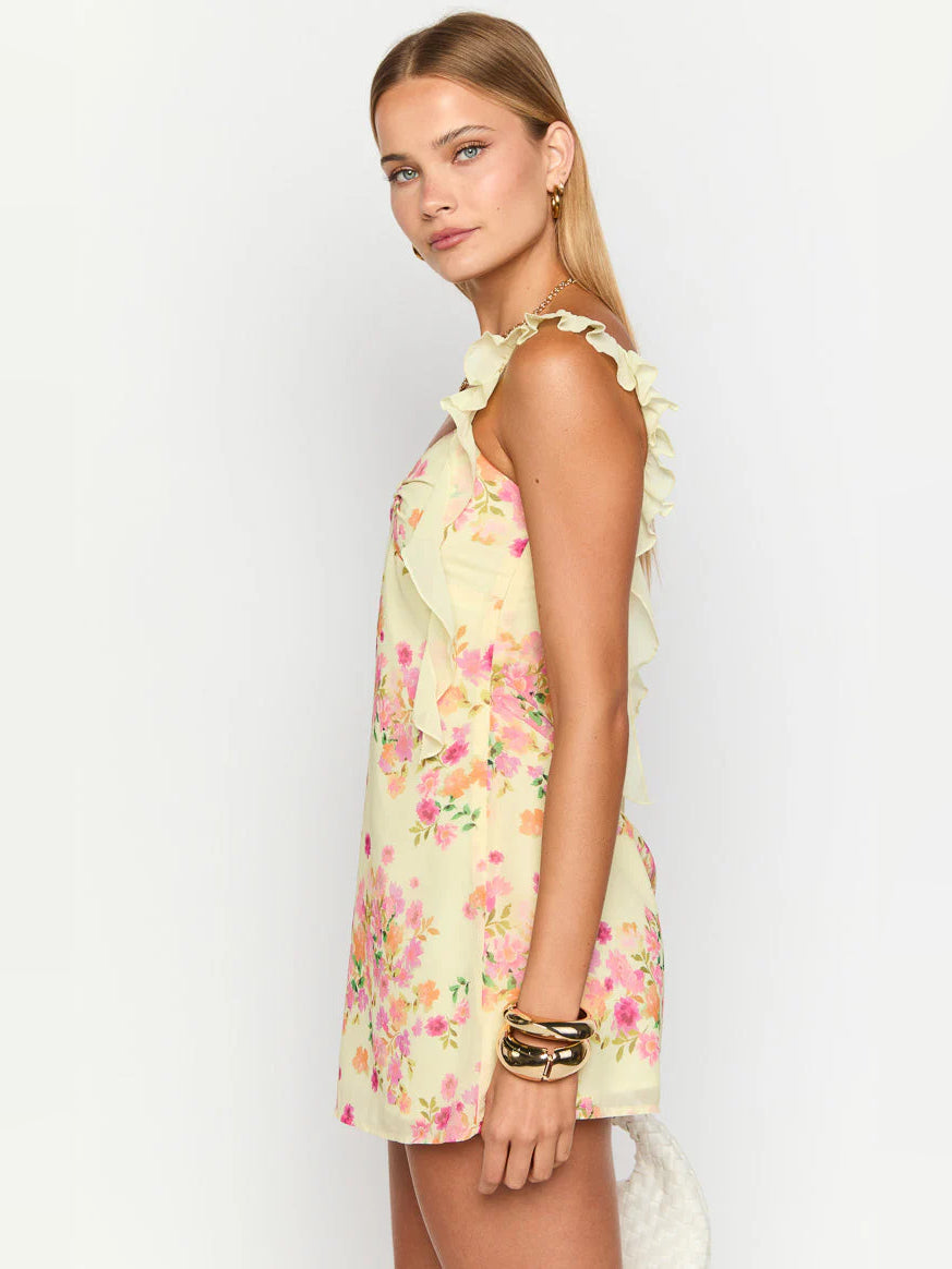 Side view of yellow floral mini dress with ruffled shoulder straps and open scoop back