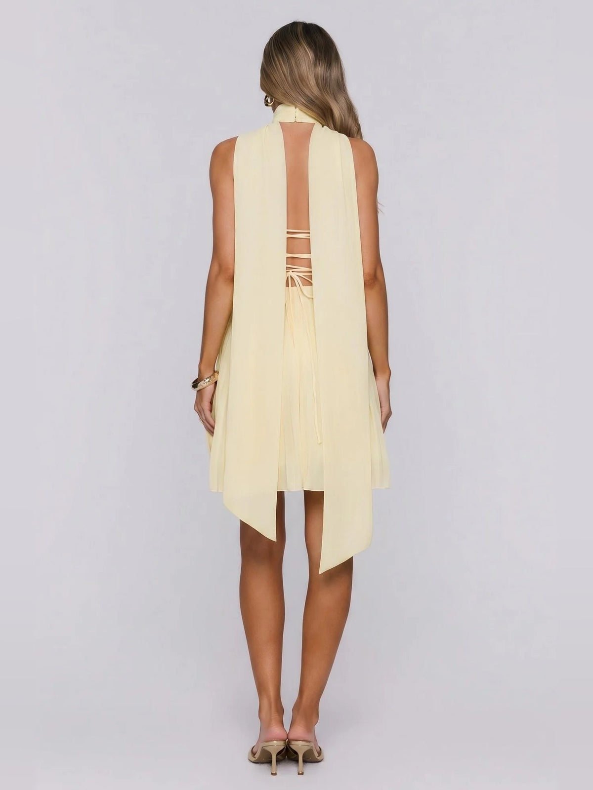 Back view: lemon yellow strapless mini dress with open cross-back and high-low hem