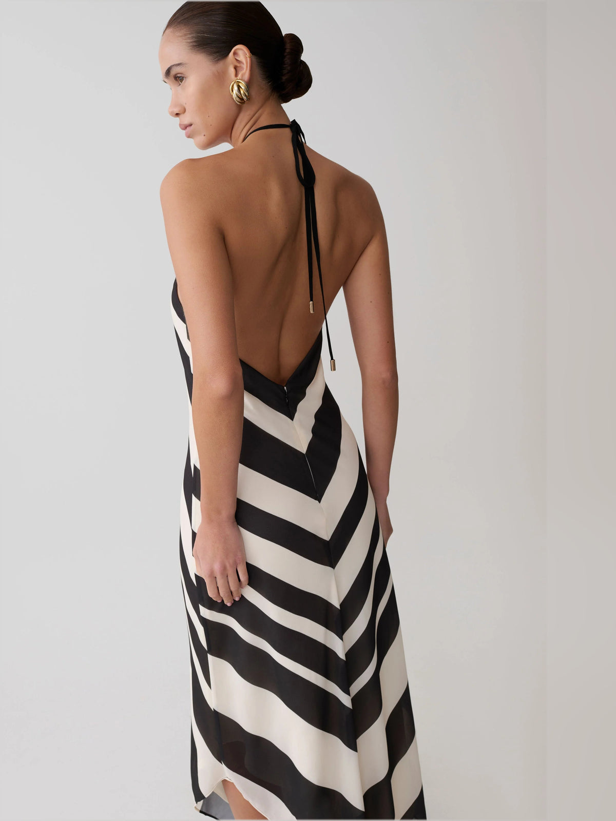 Open-back satin halter midi formal dress with black-and-white chevron zigzag pattern.