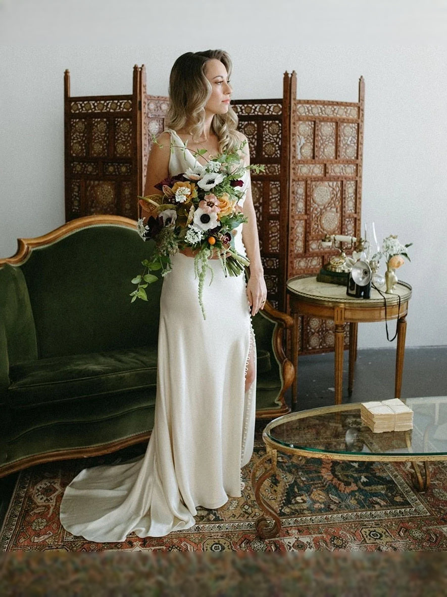 Ivory satin mermaid maxi dress on a woman holding a floral bouquet, draped corset