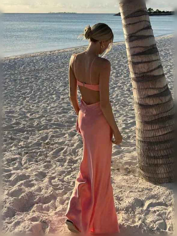 Pink satin floor-length dress with open-back straps and backless cutout at waist