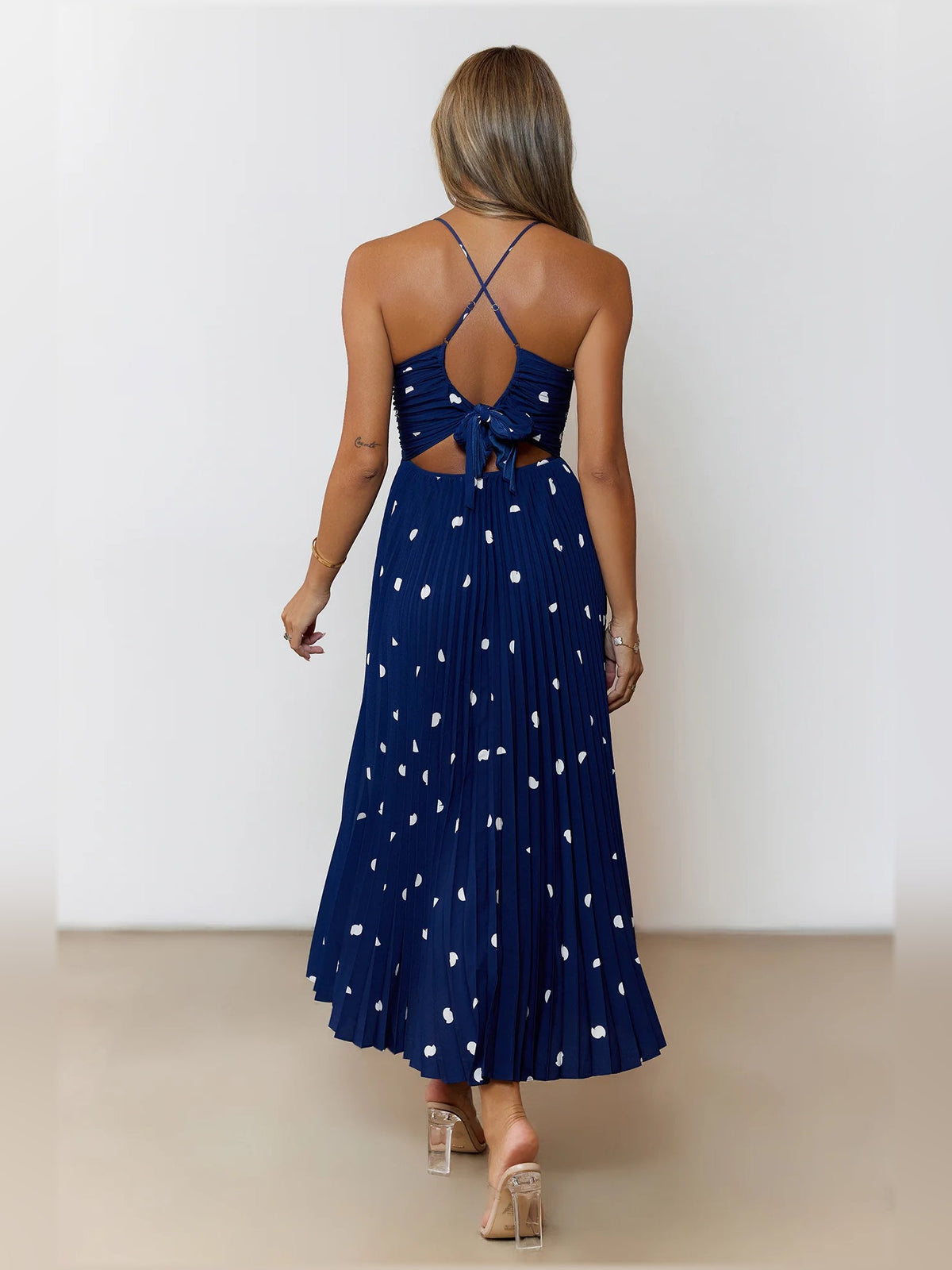 Back view of navy midi dress with crisscross spaghetti straps and white dot print