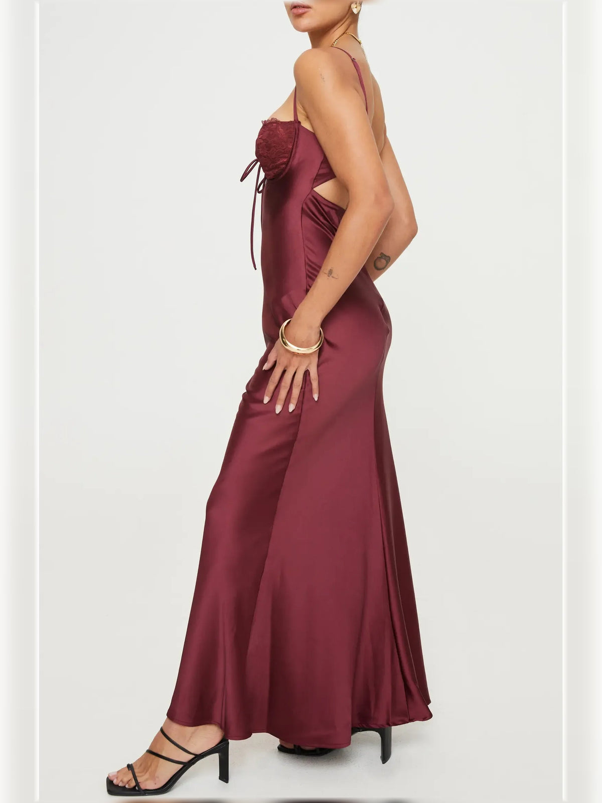 Dark red satin formal dress with spaghetti straps, ruched lace sweetheart bodice, side view