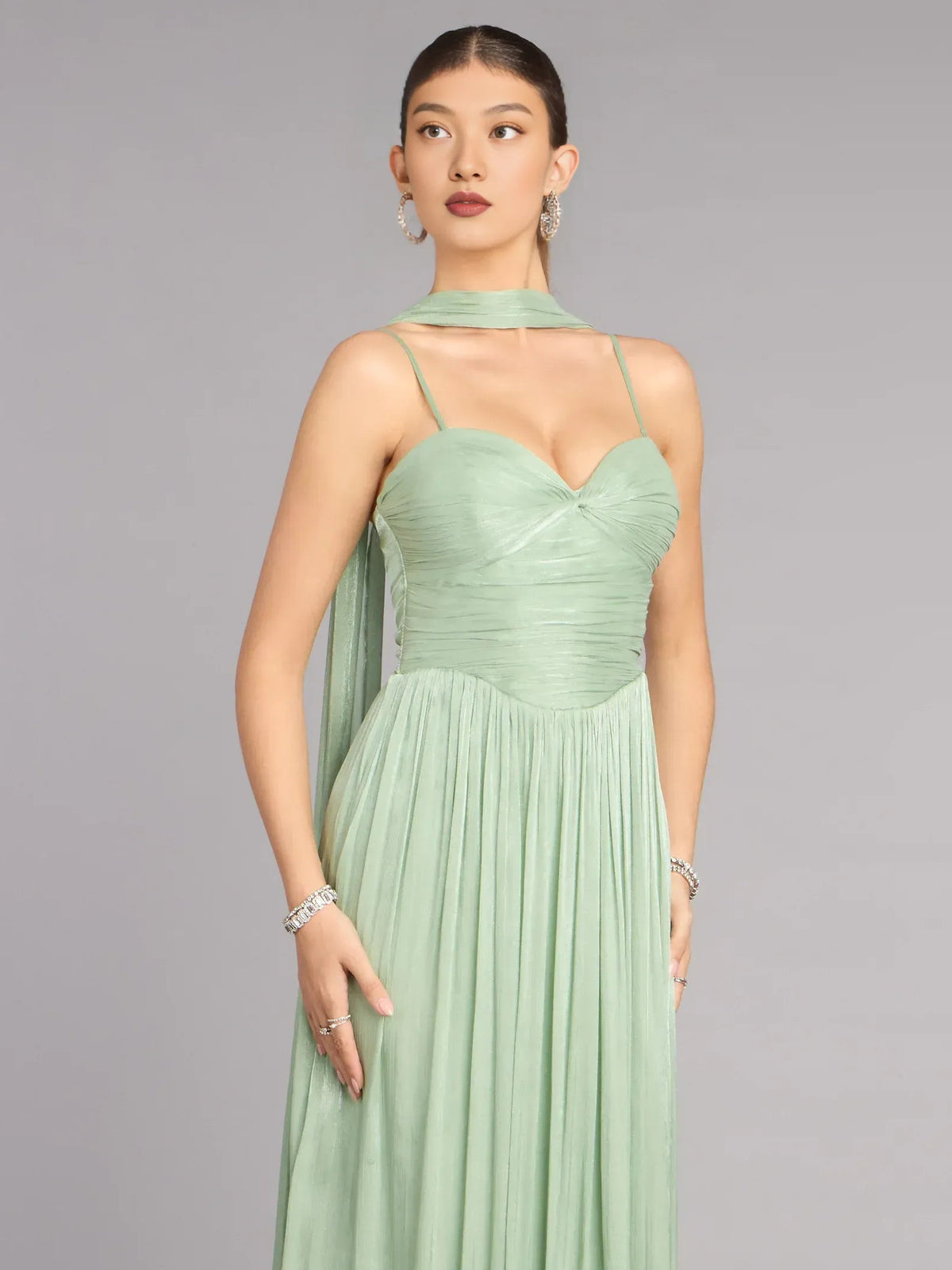 Sage green sleeveless sweetheart prom dress with thin straps, ruched bodice, pleated skirt