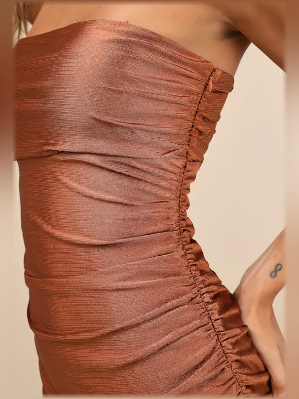 Close-up of copper ruched fabric and gathered seam detailing on dress