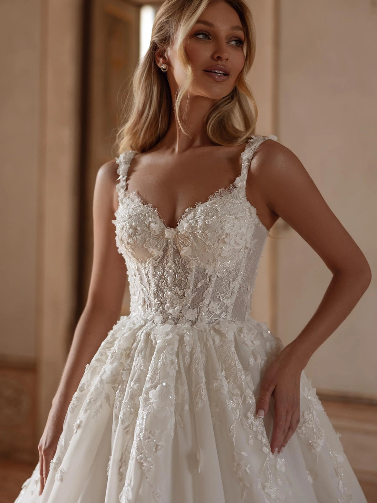 Ivory corset bodice wedding dress with floral lace V-neckline and layered skirt details