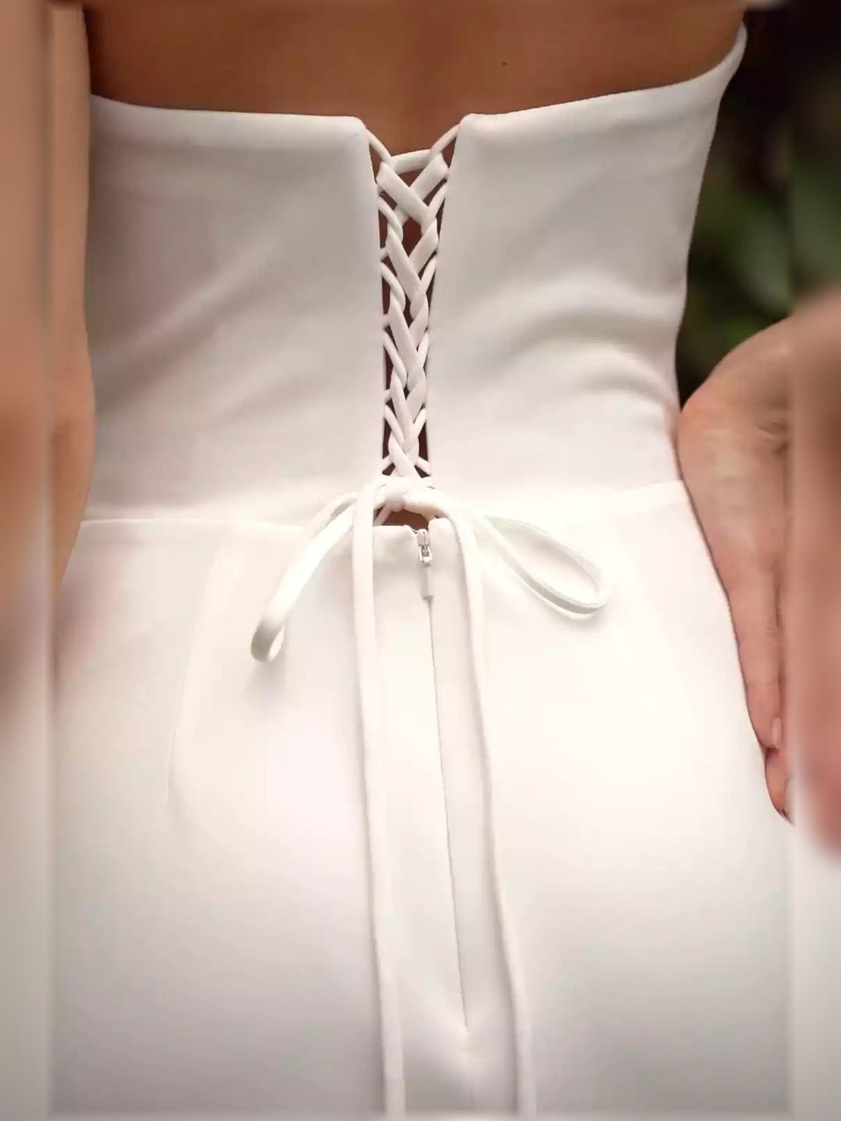 White back corset with lace-up lacing and bow-tied waist on formal dress