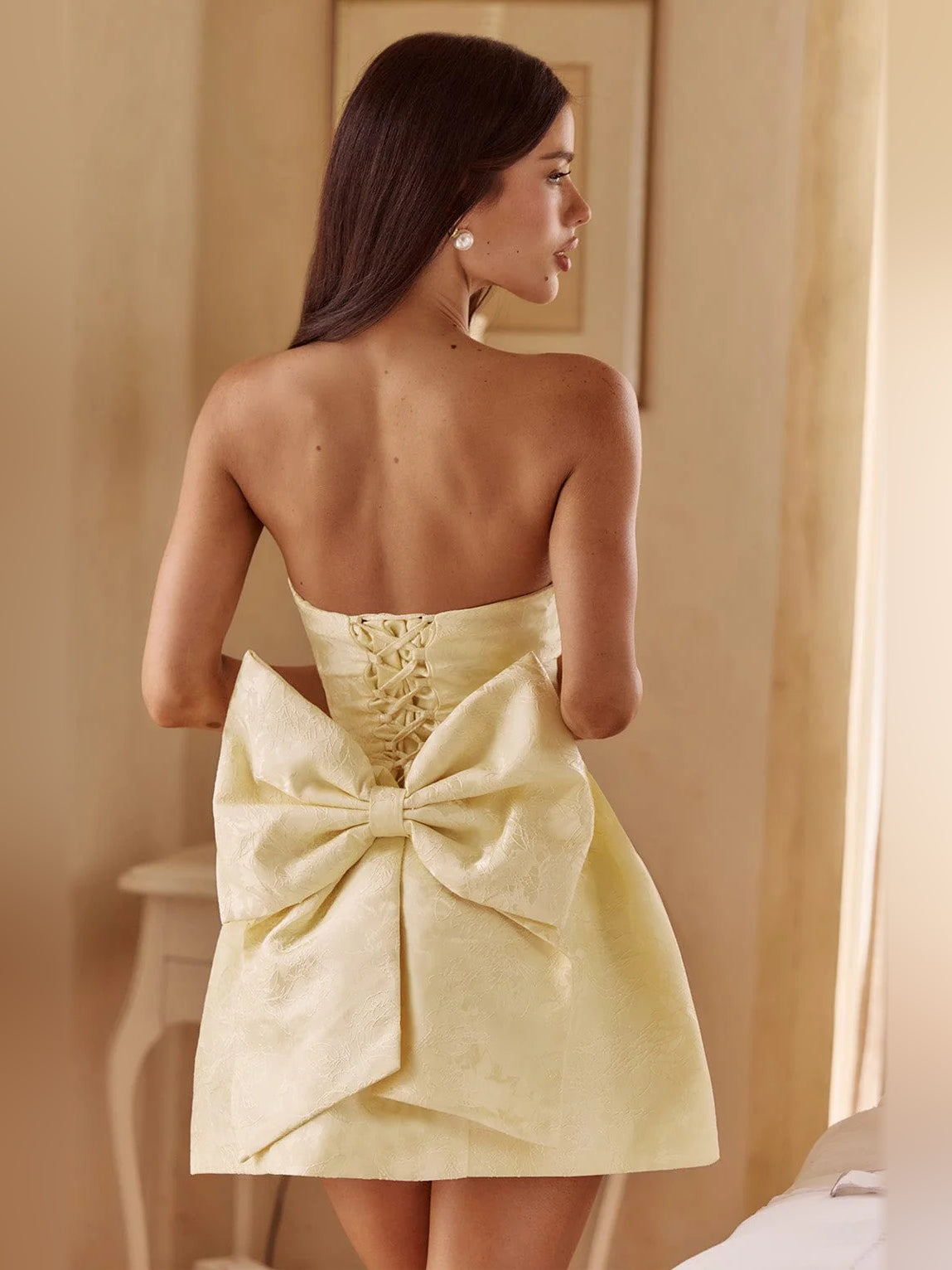 Lemon strapless mini homecoming dress with lace-up back detail and large bow
