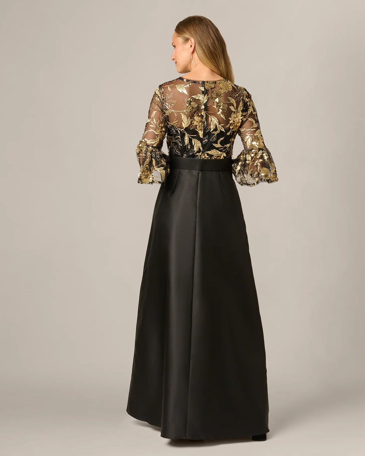 Black A-line maxi dress with gold embellished sleeves and belted back
