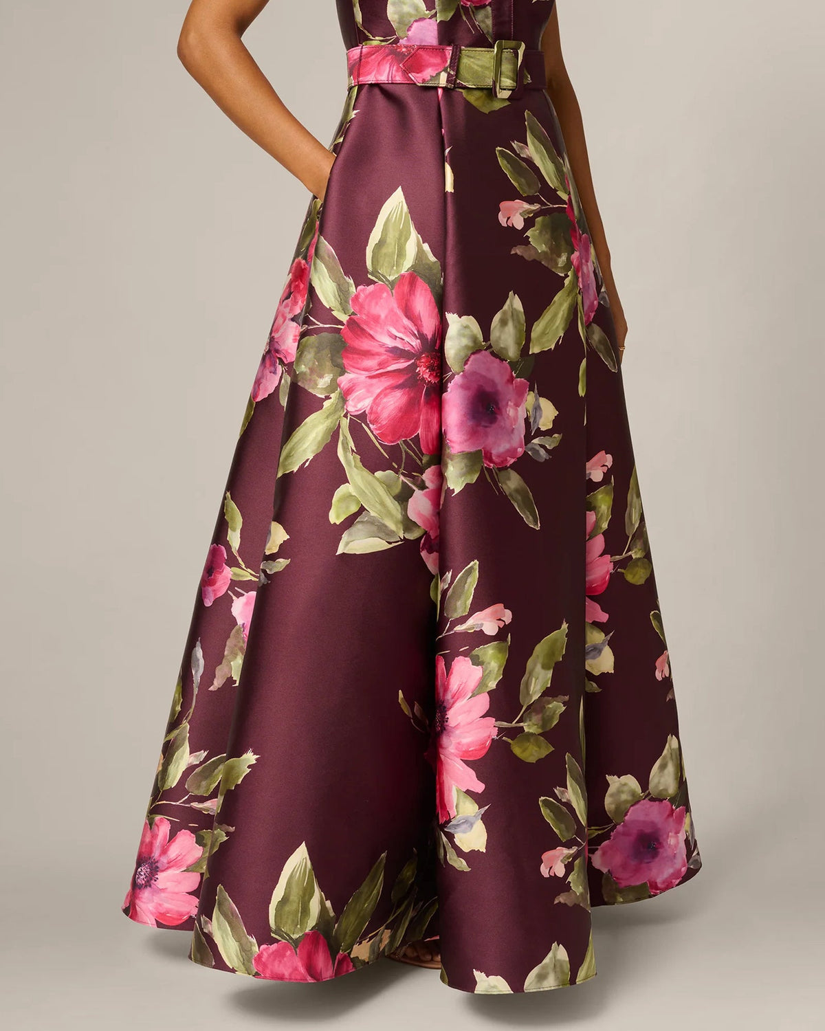 Burgundy floral maxi dress with gold-buckle belt at waist and flowing A-line skirt