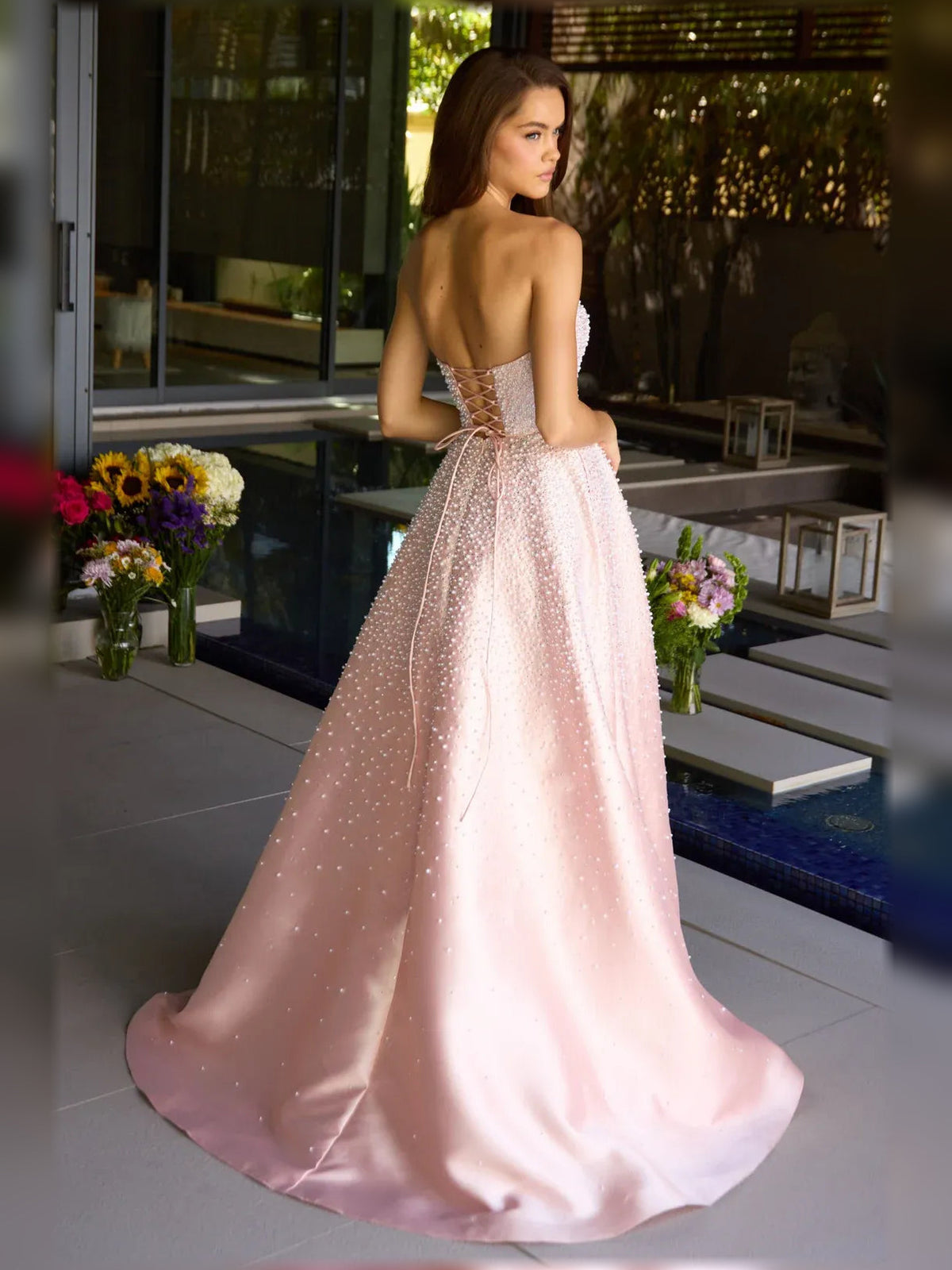 Blush pink strapless beaded corset formal dress with full floor-length skirt.