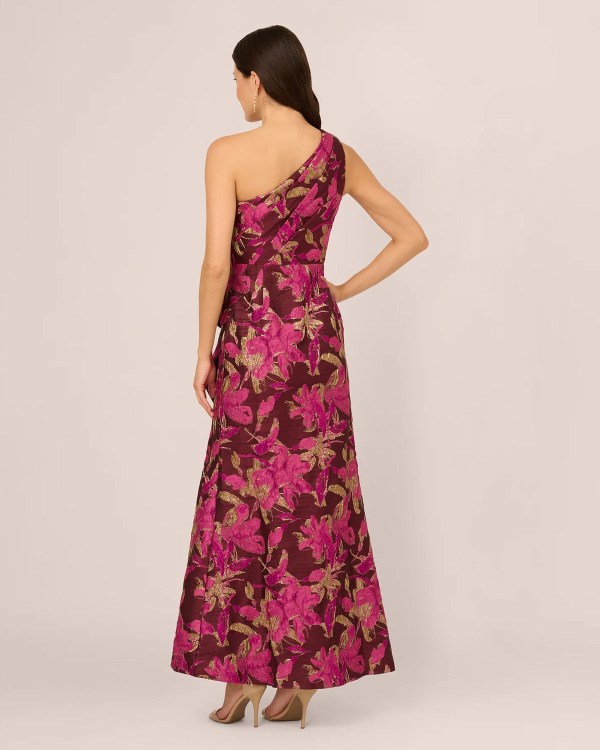 One-shoulder maxi dress back view with burgundy and gold botanical print, flowing skirt