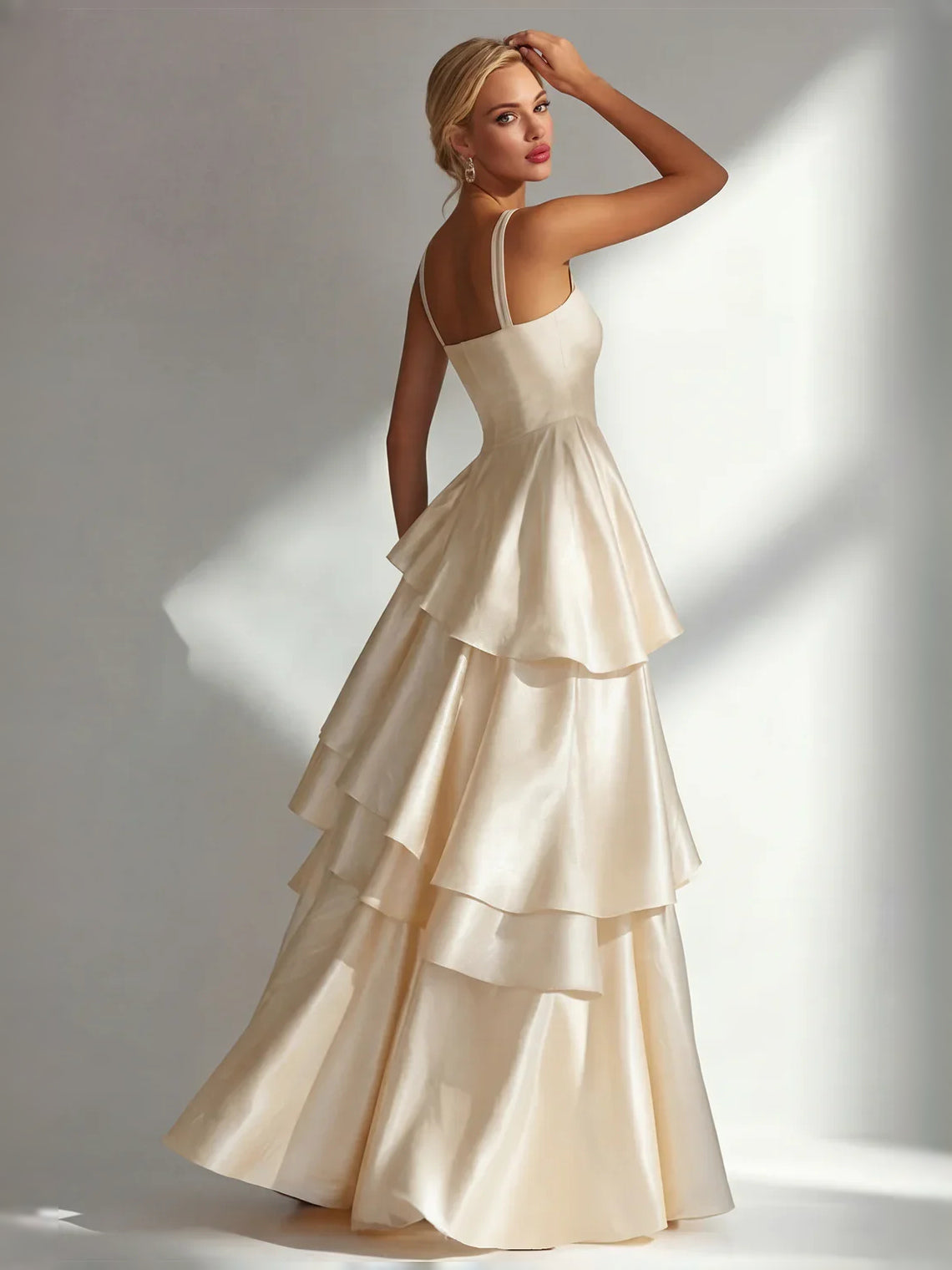 Cream satin prom dress with square neckline and thin straps, featuring tiered ruffle skirt layers.