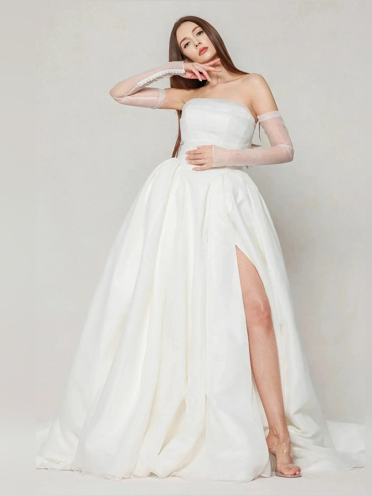 Ivory strapless ball gown with pleated skirt fullness and side slit down the leg