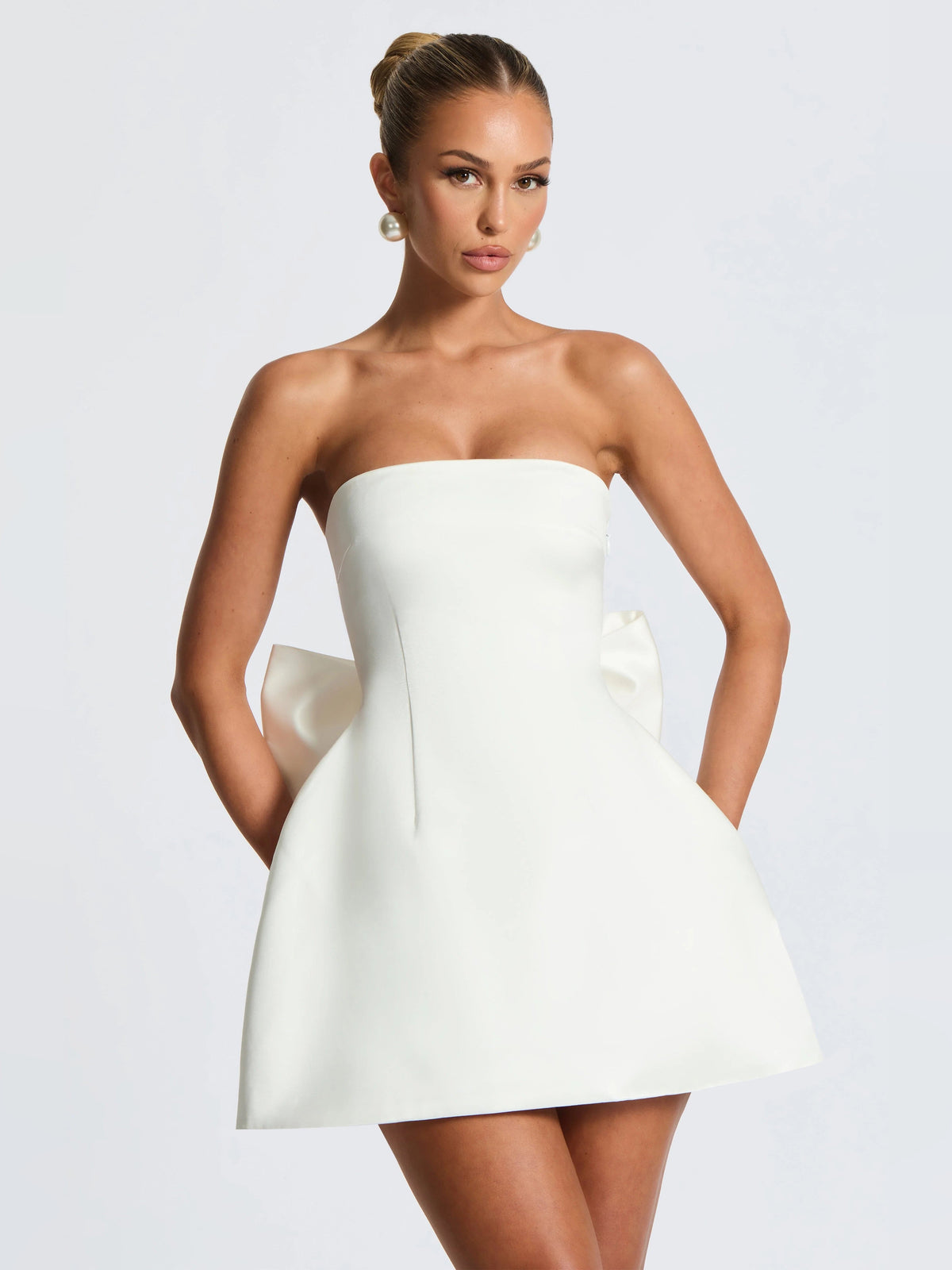 Ivory strapless mini dress with fitted bodice and layered skirt flare, angled front view.