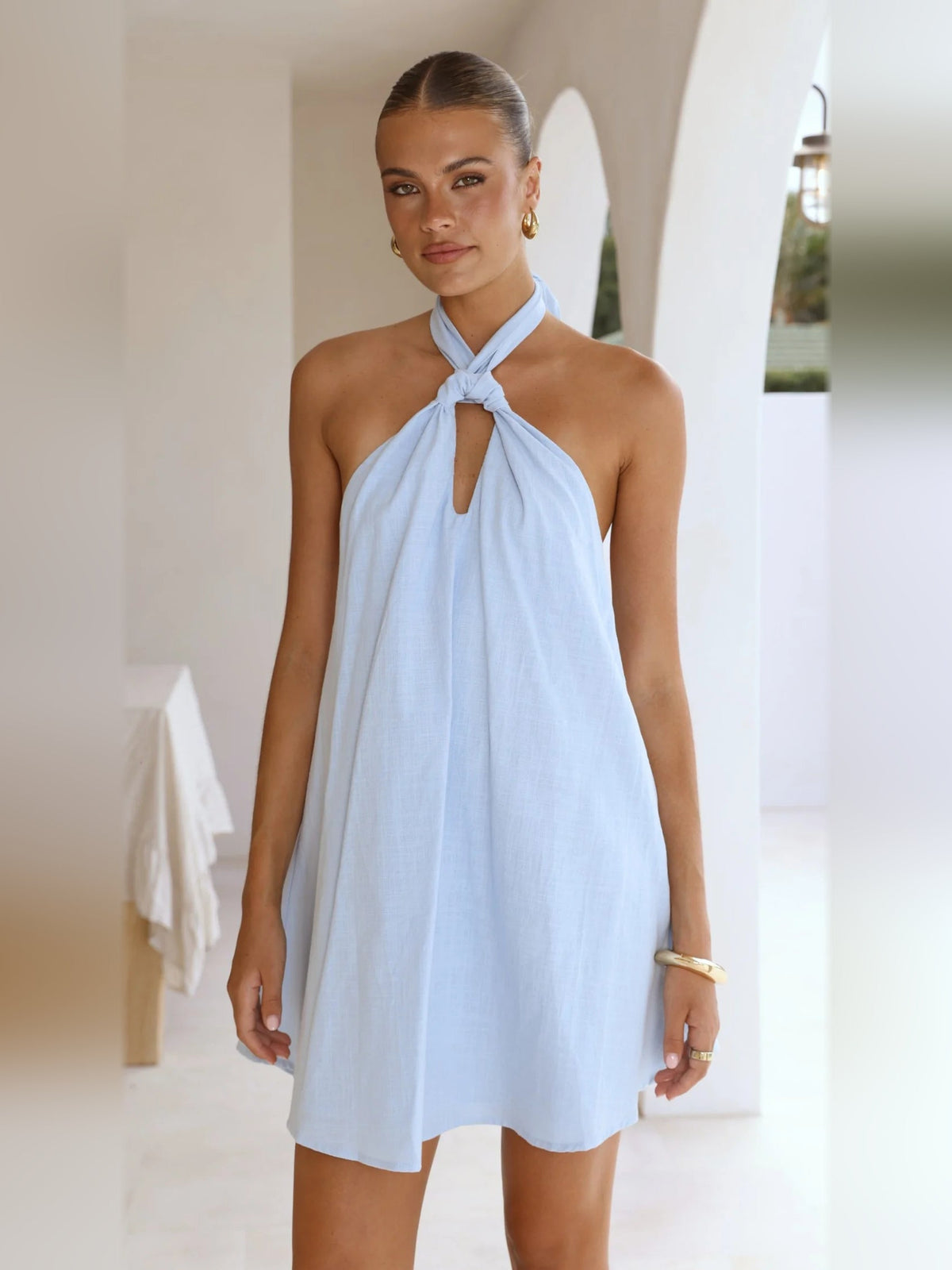 Light blue halter mini dress with bow tie neckline and flowing skirt