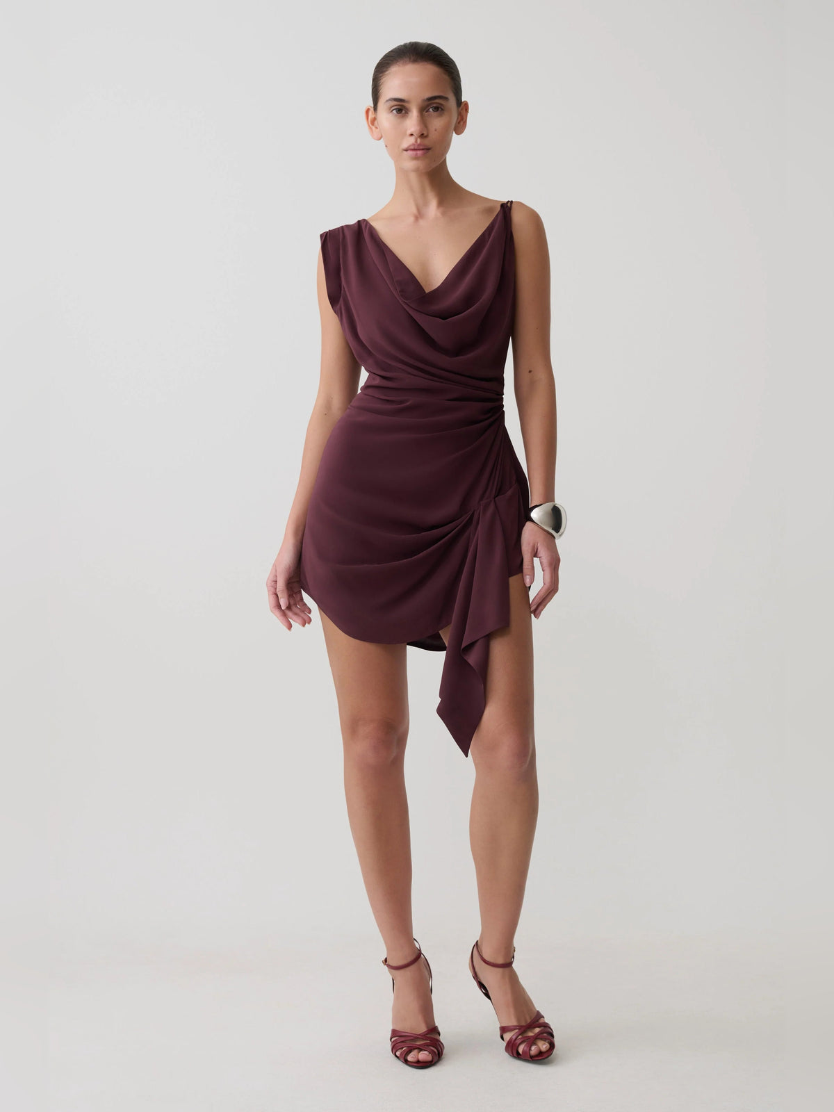 Plum satin mini dress with cowl neckline, sleeveless cut, and draped side sash