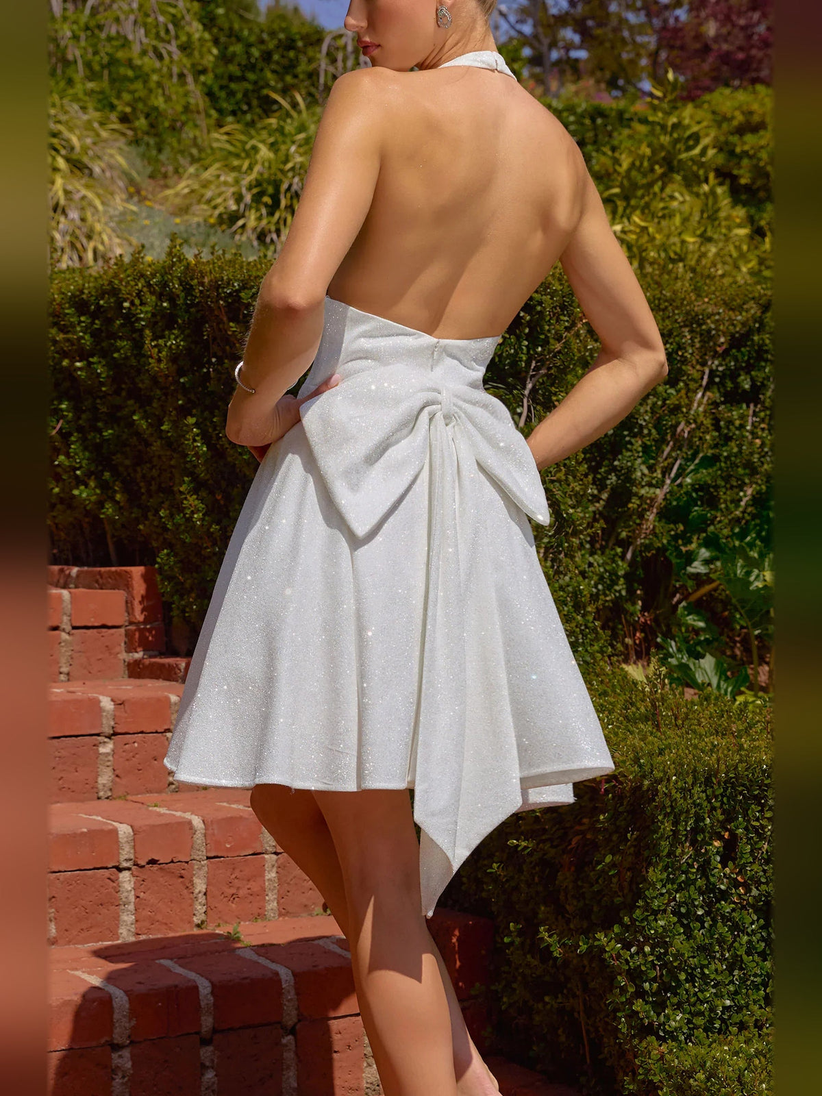 Sparkly white open-back A-line mini dress with V-neck and waist bow