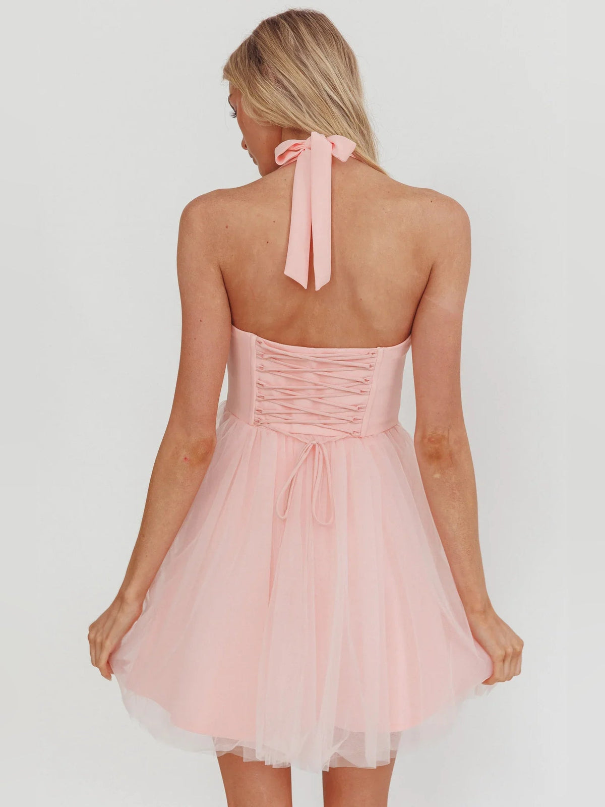 Blush pink open-back halter corset mini dress with tie bow