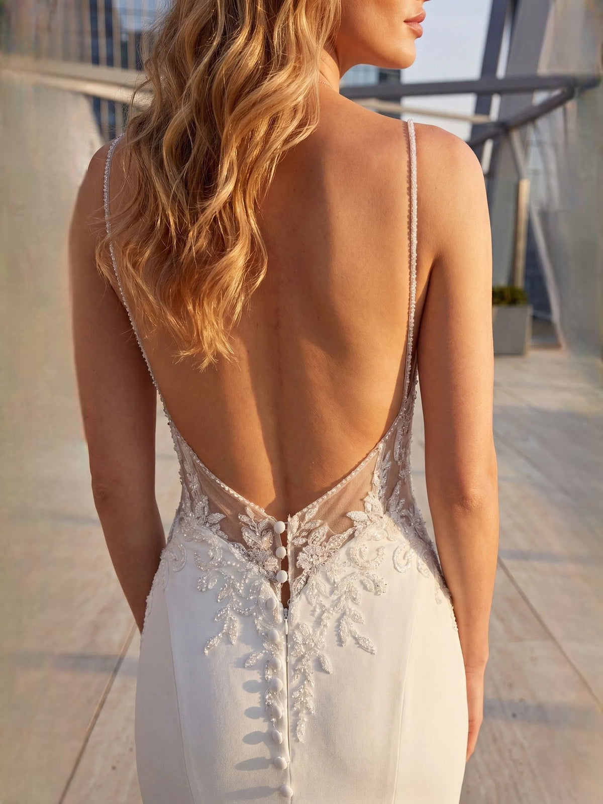 White lace mermaid wedding dress back view with button-like detailing and thin straps