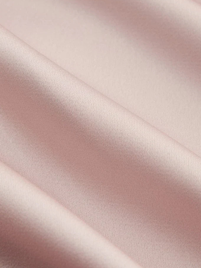 Blush pink satin fabric swatch with smooth sheen and subtle diagonal folds