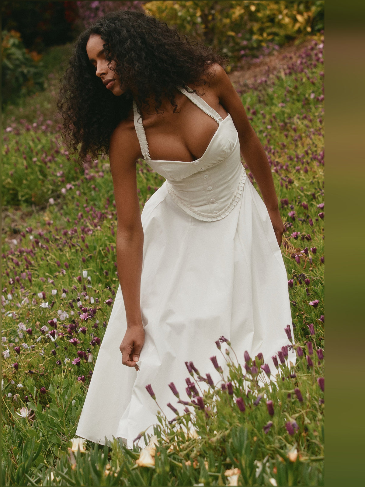 White halter-neck midi dress with ruched cups and pleated skirt, side profile