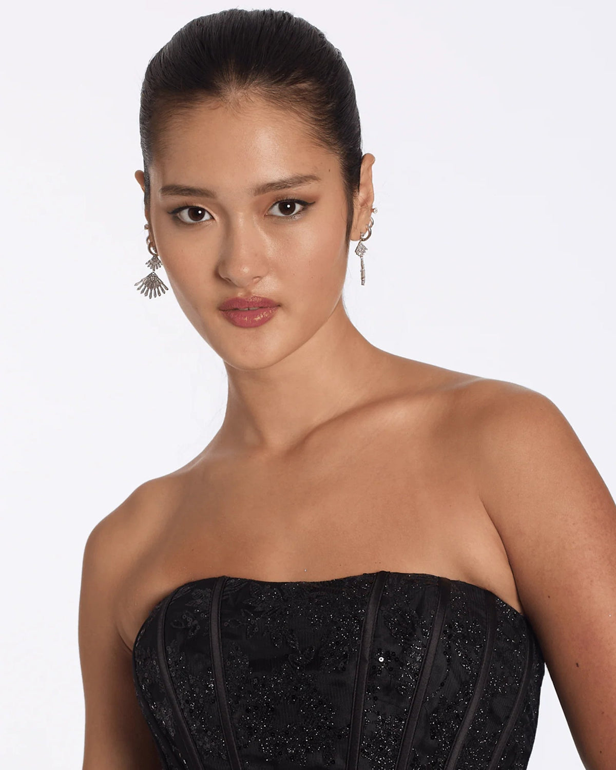 Close-up of black strapless embellished corset bodice with corset lacing details and sparkle