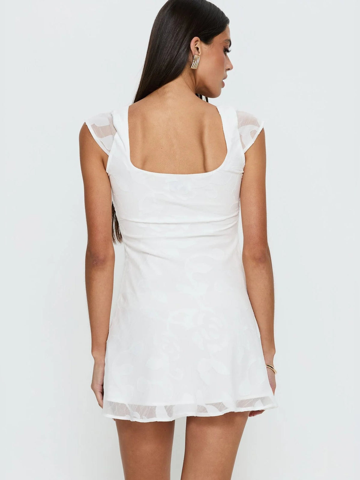 White floral mini dress, back view with square yoke, cap sleeves, flared skirt hem