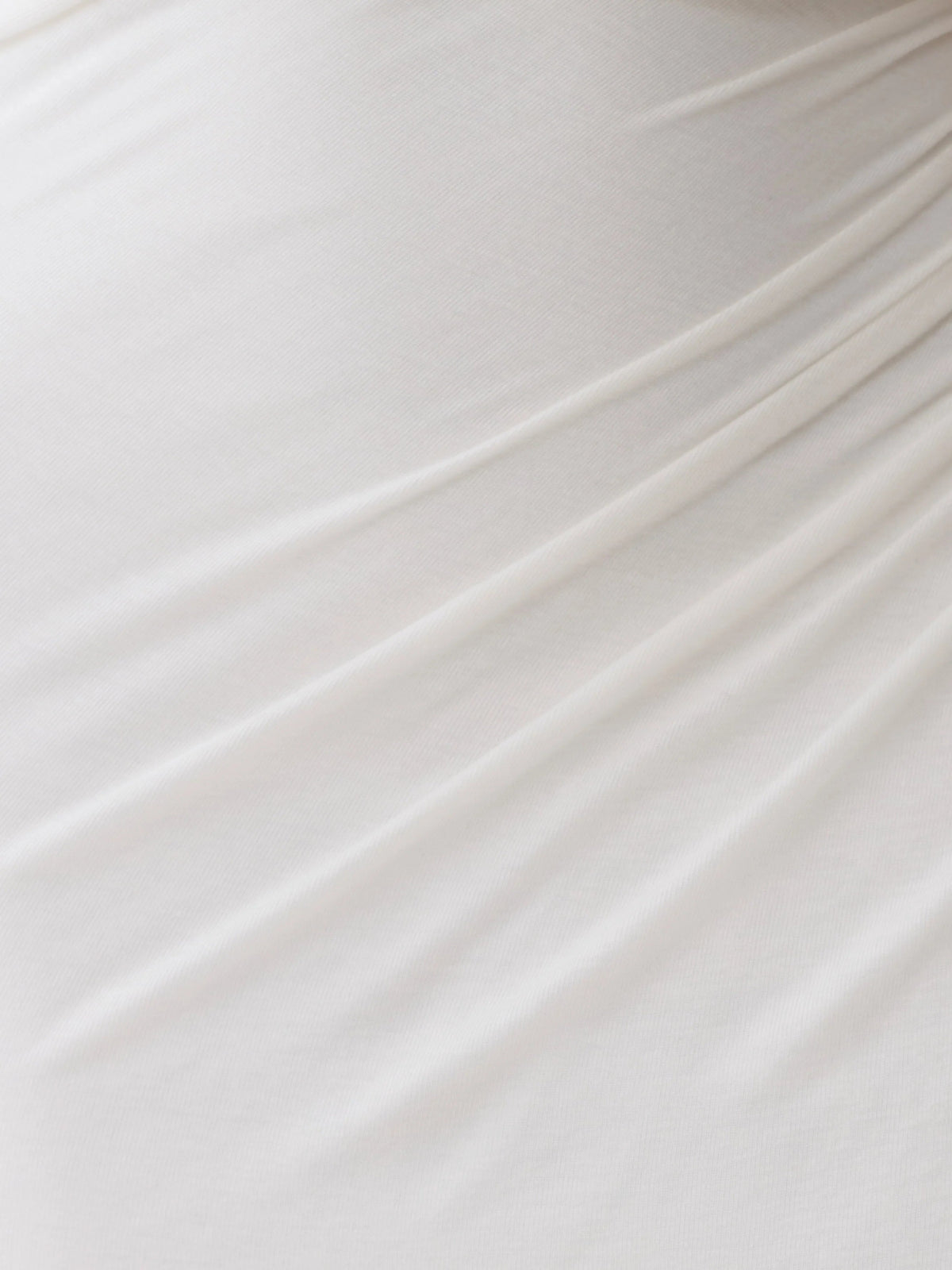 White fabric close-up with smooth drape and gathered texture