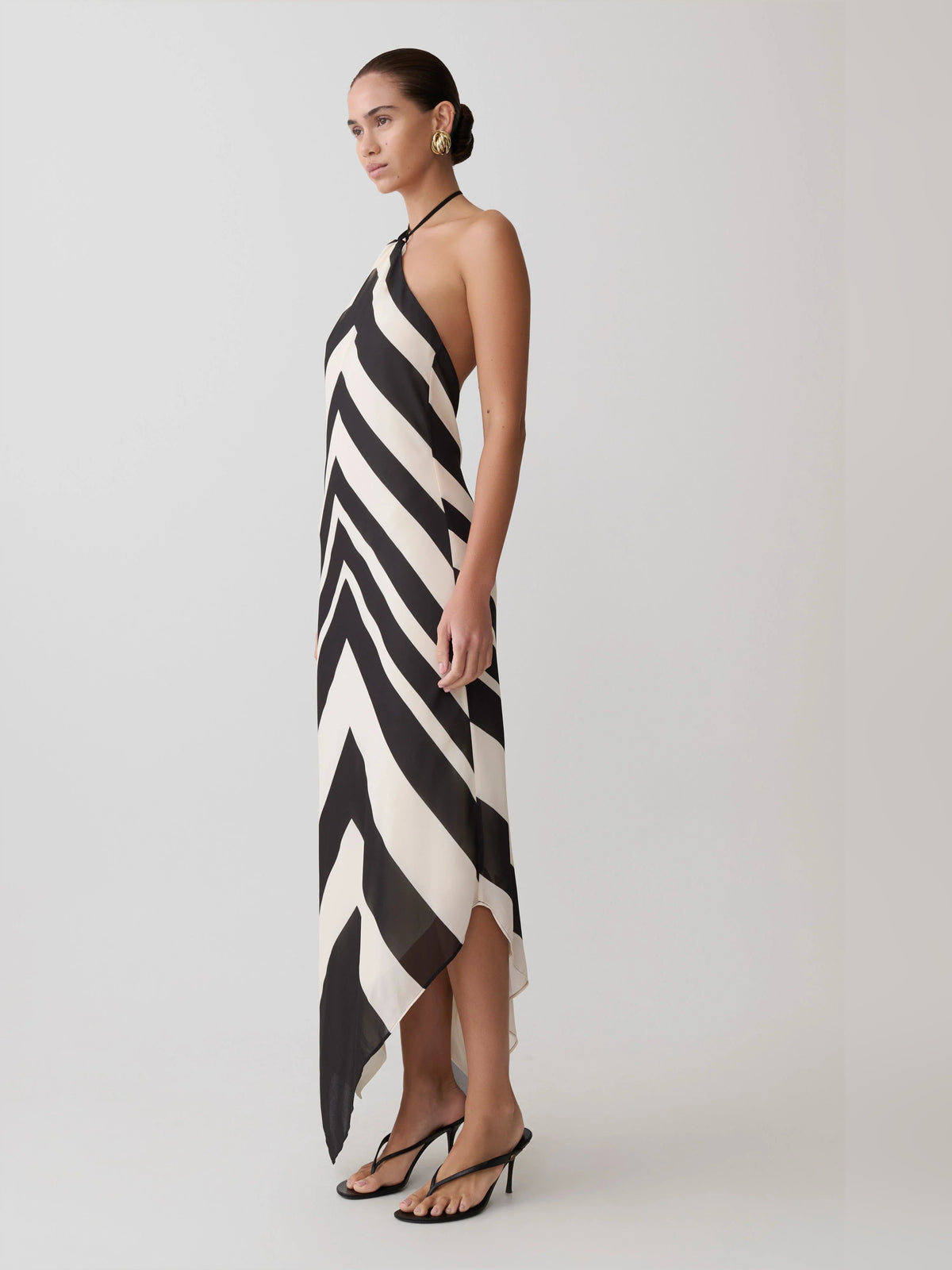 Halter midi formal dress with black-and-white chevron zigzag print and draped asymmetrical hem.
