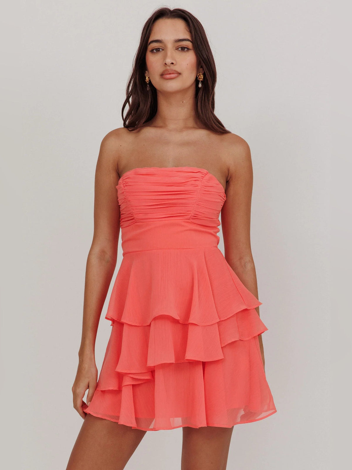 Peach coral strapless mini dress with ruched bodice and cascading ruffles