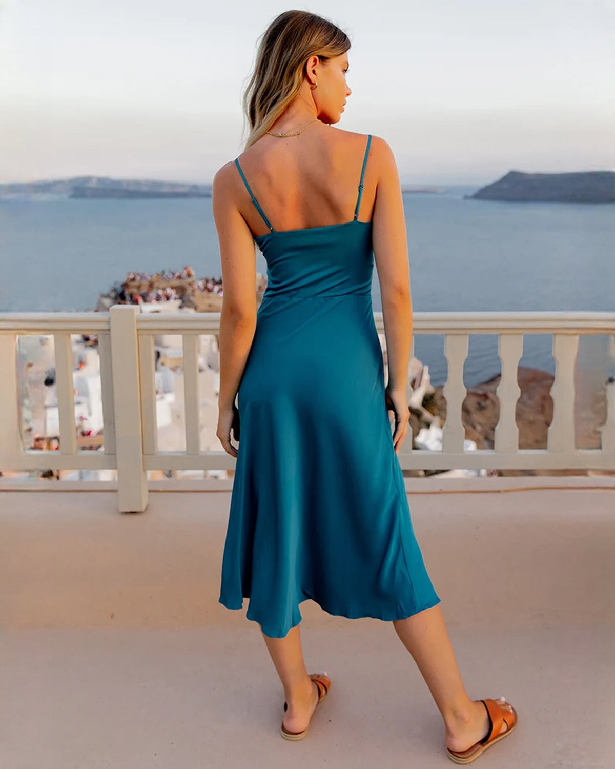 Back view of teal satin A-line midi dress with thin straps and open back
