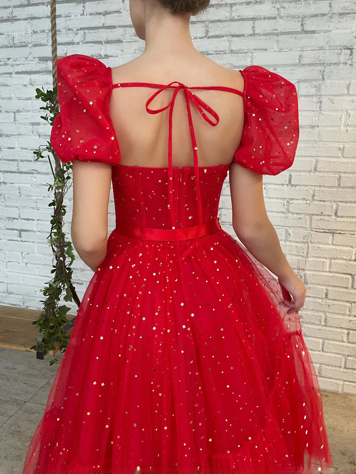 Red corset back midi tulle prom dress with ribbon tie, puff sleeves, and speckled skirt