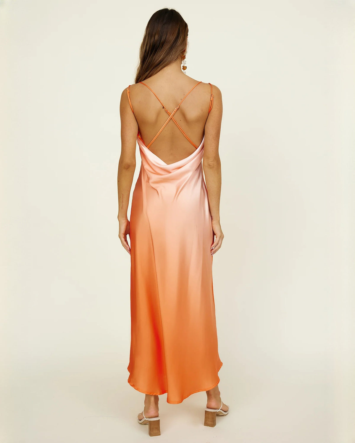 Back view of peach orange satin maxi dress with crisscross straps and open back