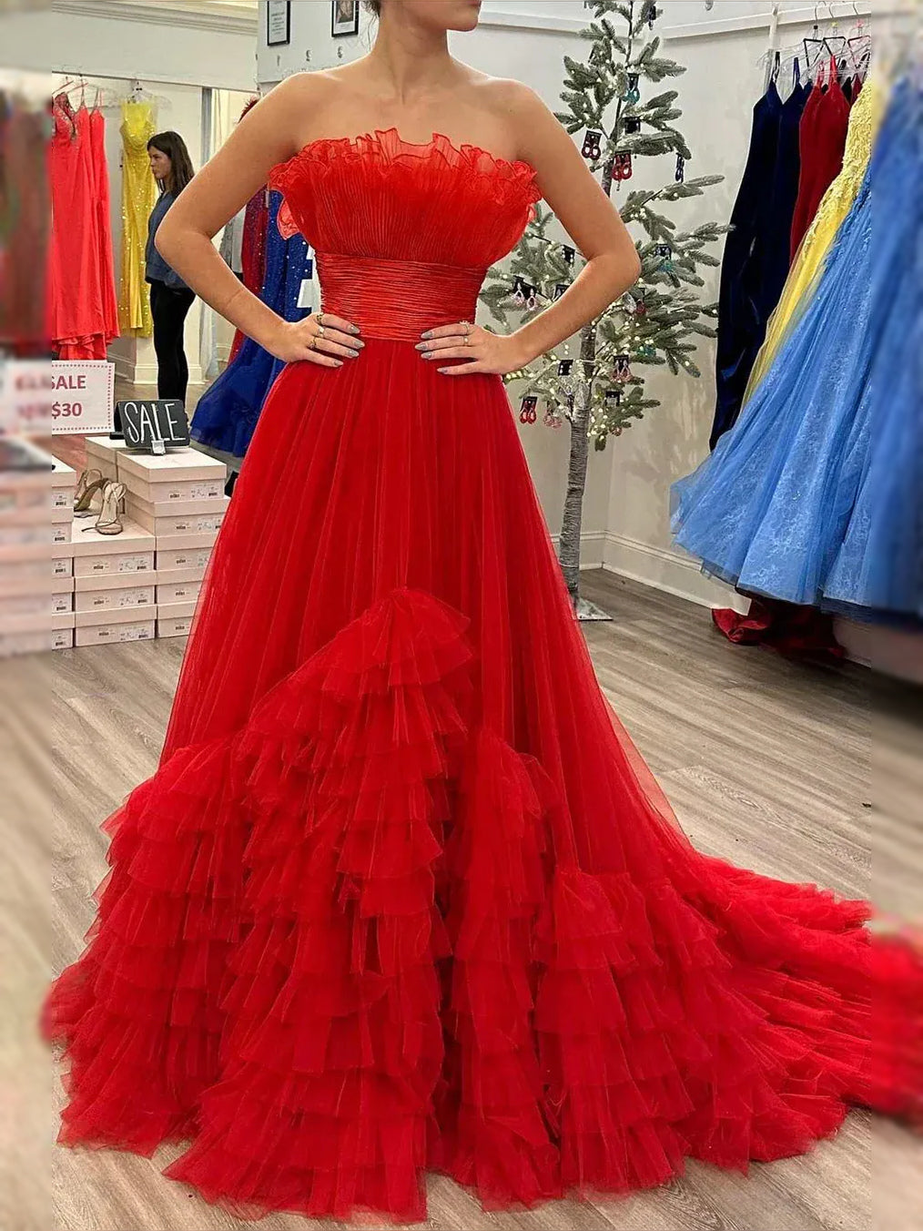 Red strapless sweetheart maxi dress with ruched bodice and tiered ruffle tulle skirt.