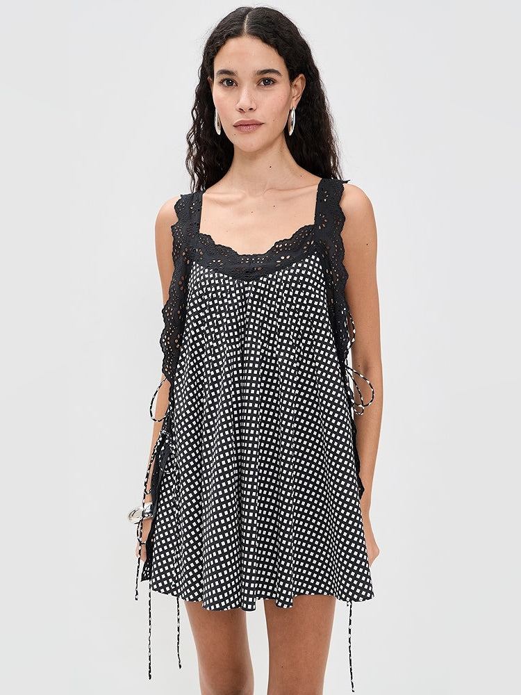 Black mini dress with white grid print, scalloped lace-trim neckline, flared ruffled hem