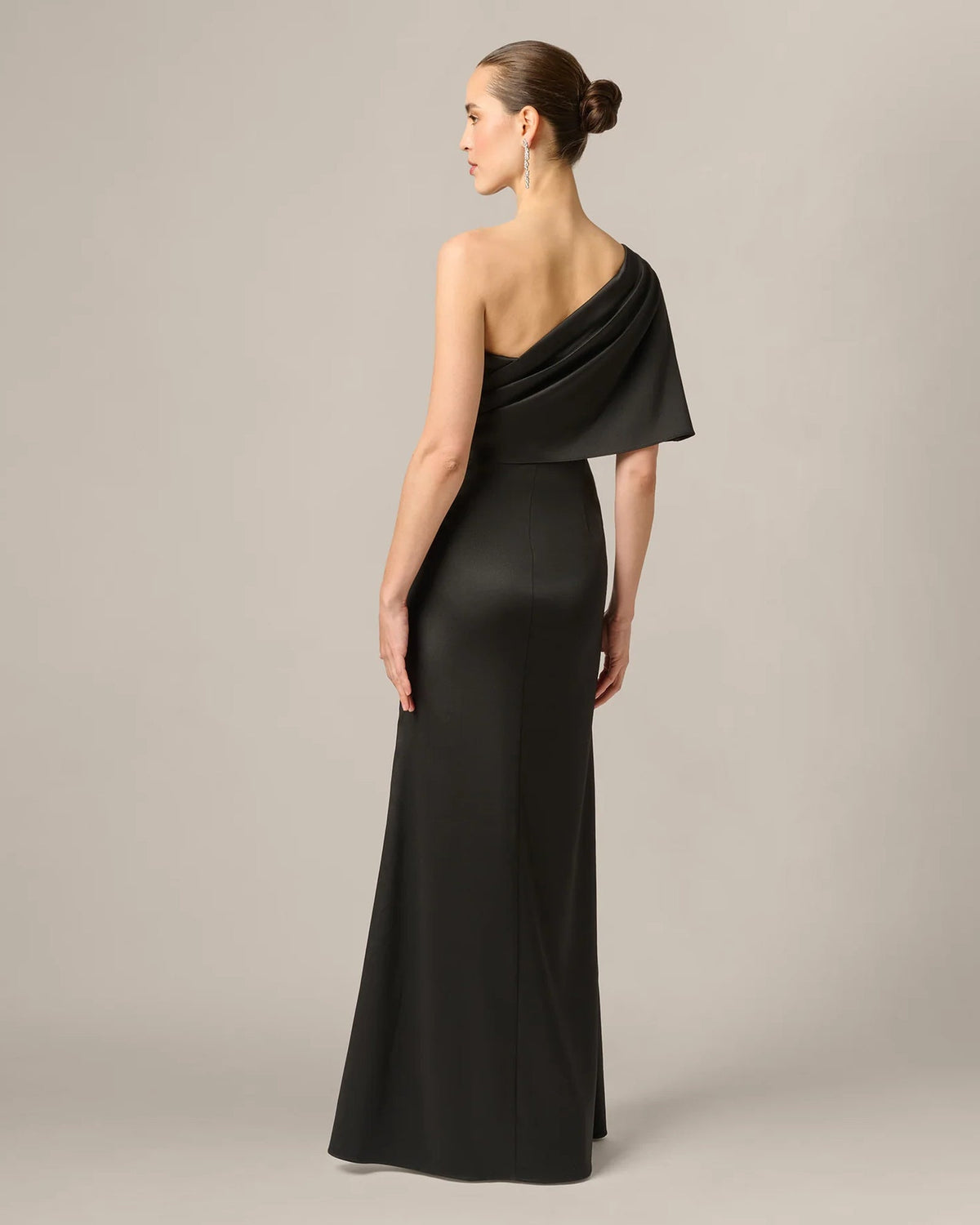 Black one-shoulder draped maxi dress shown from back with wrapped shoulder