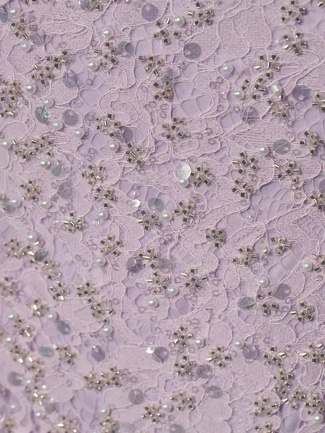 Lilac beaded lace overlay fabric with sequins and small pearls, close-up
