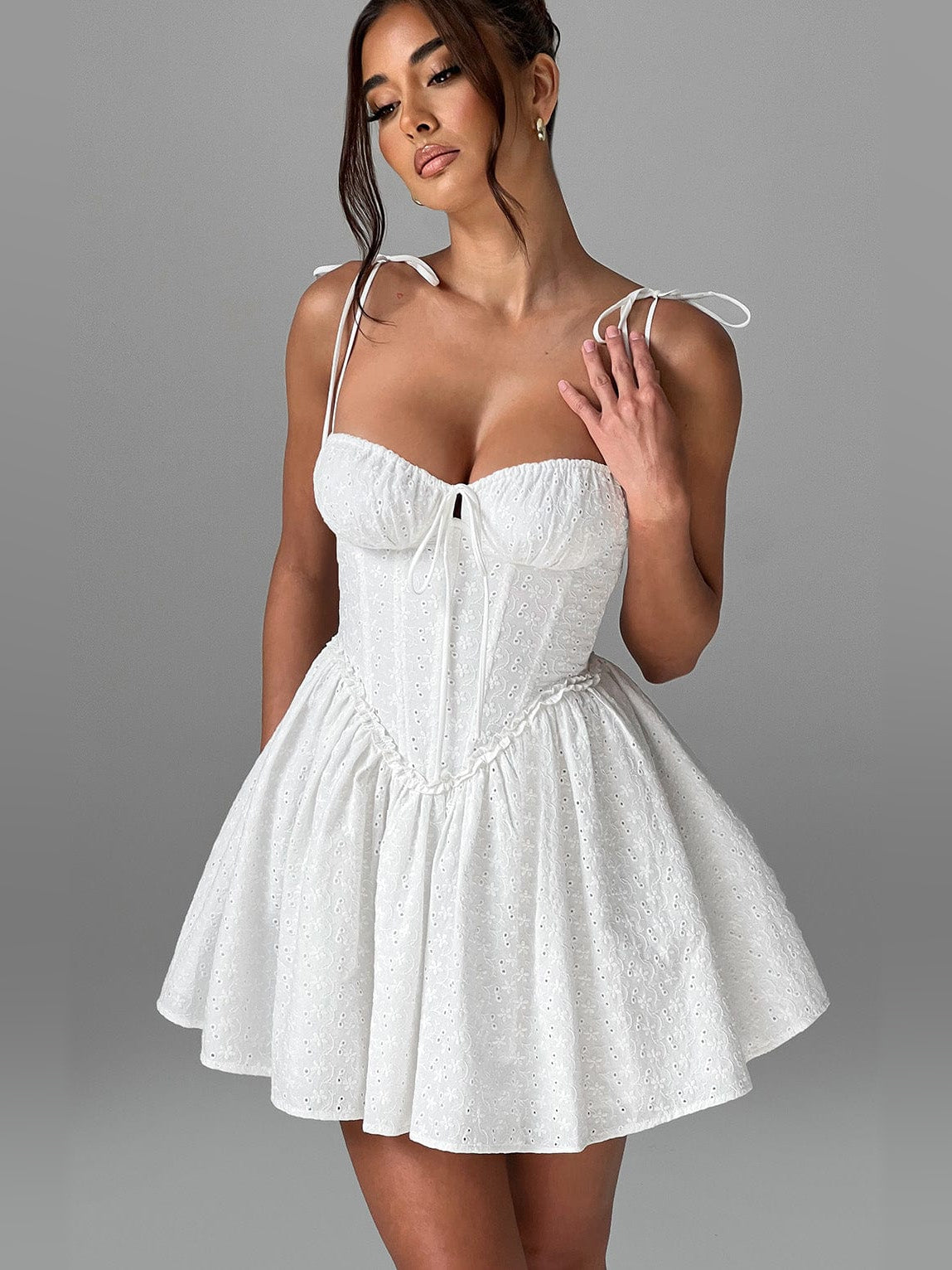 Ivory mini dress with corset bodice, thin tie shoulder straps, and textured flared skirt